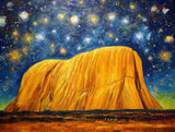 large orange rock formation beneath a star-filled sky