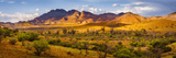 Mountain range in outdoor natural landscape beneath layered mountains beneath a partly cloudy sky