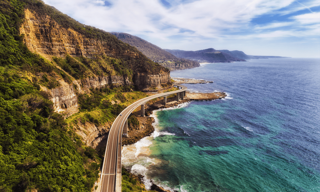 Curving elevated roadway along a rocky coastline in rocky shoreline with an elevated roadway between cliffs and ocean