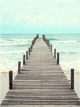 Wooden pier stretching over calm water in pale aqua, grey, muted brown tones in a waterfront setting